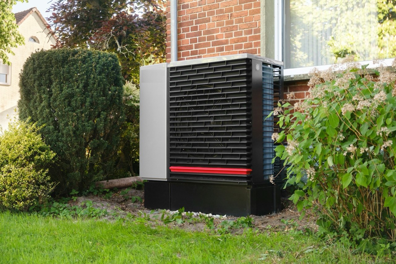 An air source heat pump outside a brick house