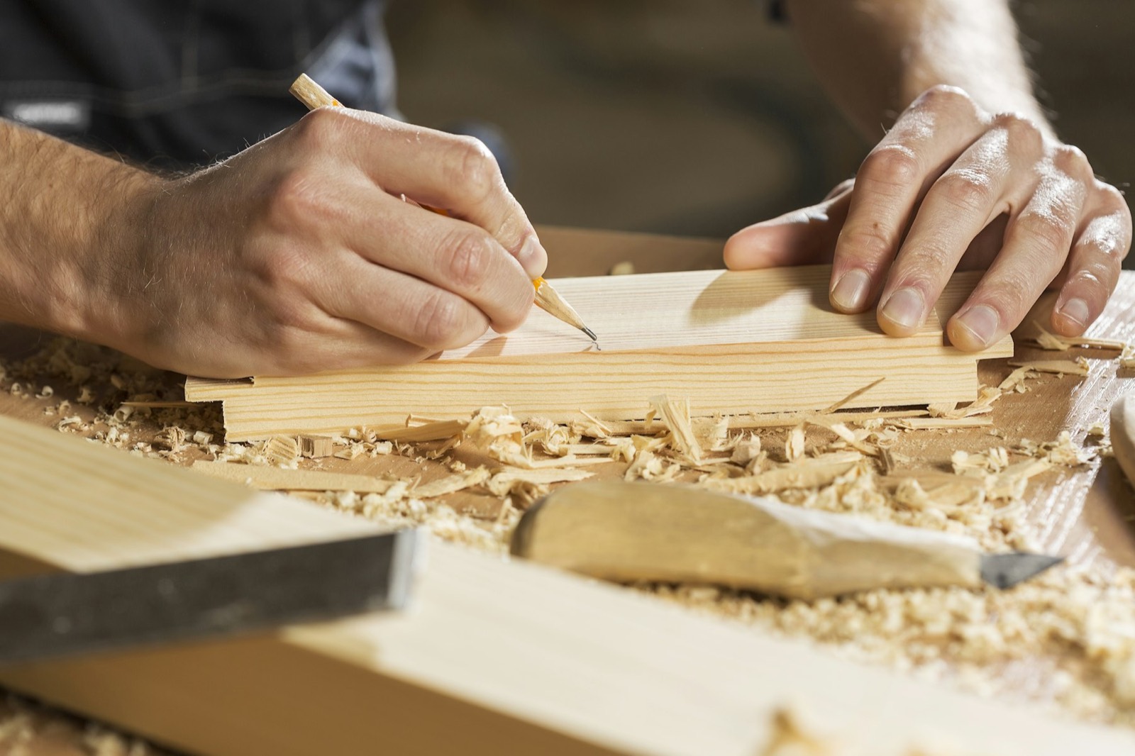A tradesperson marking a length of timber